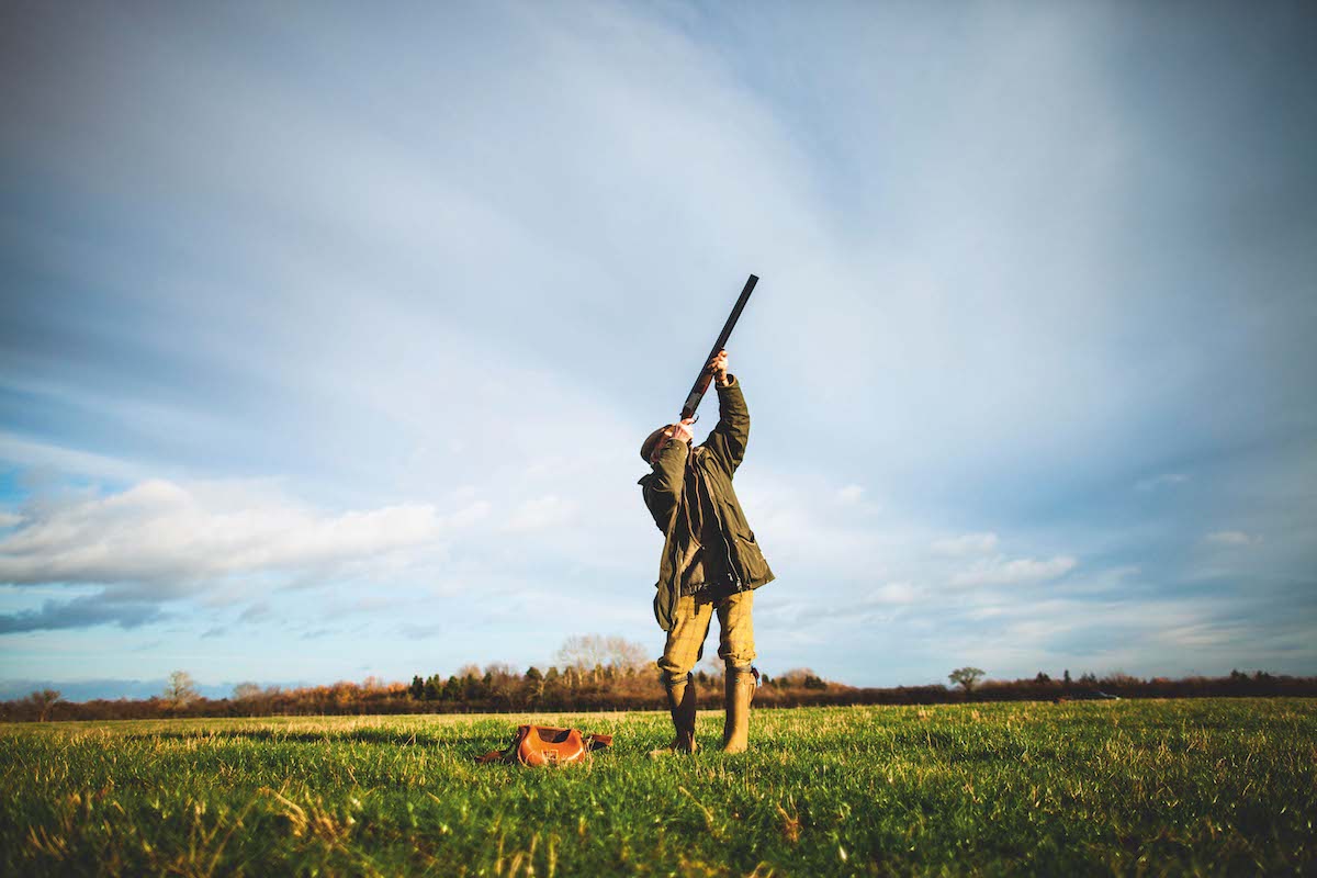 man shooting shotgun